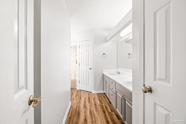 bathroom featuring vanity, wood-type flooring, and a textured ceiling