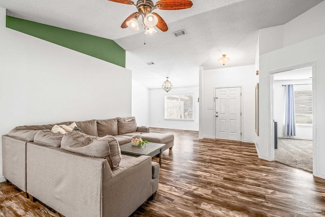 living room with lofted ceiling, plenty of natural light, dark wood finished floors, and a ceiling fan