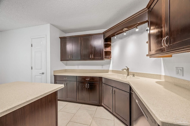 kitchen featuring light countertops, dark brown cabinetry, a sink, open shelves, and stainless steel dishwasher