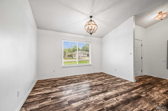 unfurnished room featuring a textured ceiling, baseboards, wood finished floors, vaulted ceiling, and a notable chandelier