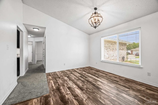 interior space featuring lofted ceiling, baseboards, a textured ceiling, dark wood-style floors, and a notable chandelier