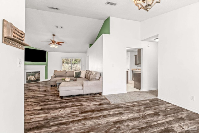 living room with ceiling fan with notable chandelier, wood-type flooring, a textured ceiling, and high vaulted ceiling