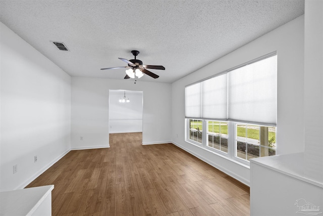 1213 Tecumseh Pl, Pensacola, FL 32514 - empty room with ceiling fan, wood finished floors, a textured ceiling, and a chandelier