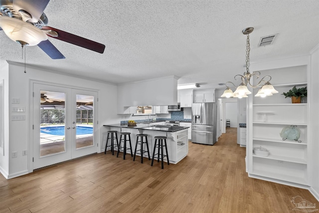 1213 Tecumseh Pl, Pensacola, FL 32514 - kitchen featuring stainless steel appliances, dark countertops, french doors, ceiling fan, and a peninsula