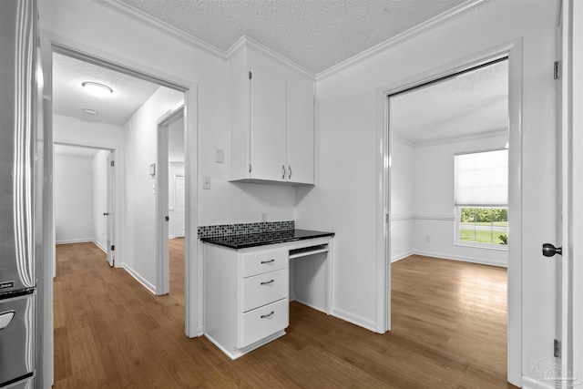 1213 Tecumseh Pl, Pensacola, FL 32514 - kitchen featuring a textured ceiling, dark wood-type flooring, white cabinets, dark countertops, and crown molding