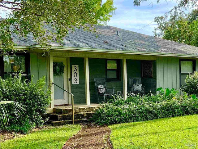 view of front of house with a porch and a front lawn