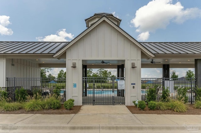 exterior space with board and batten siding, fence, and metal roof