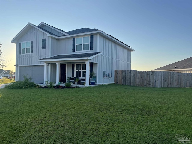 view of front of property with a yard, board and batten siding, a garage, and fence