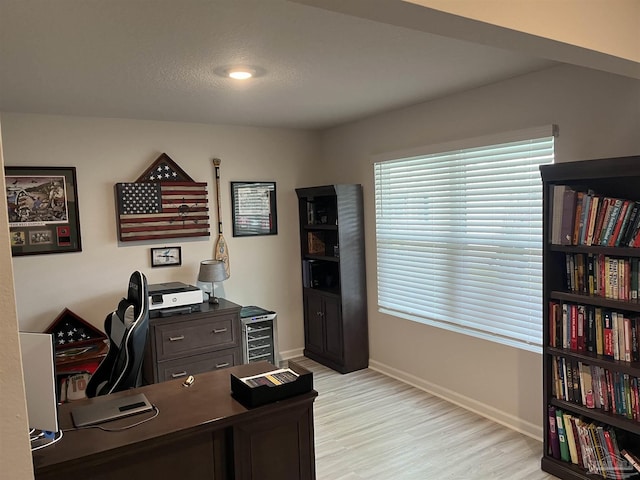 office area featuring baseboards and light wood-style flooring