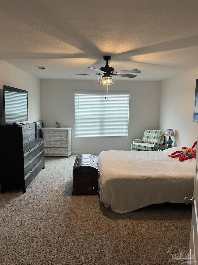 carpeted bedroom with ceiling fan, a textured ceiling, and visible vents