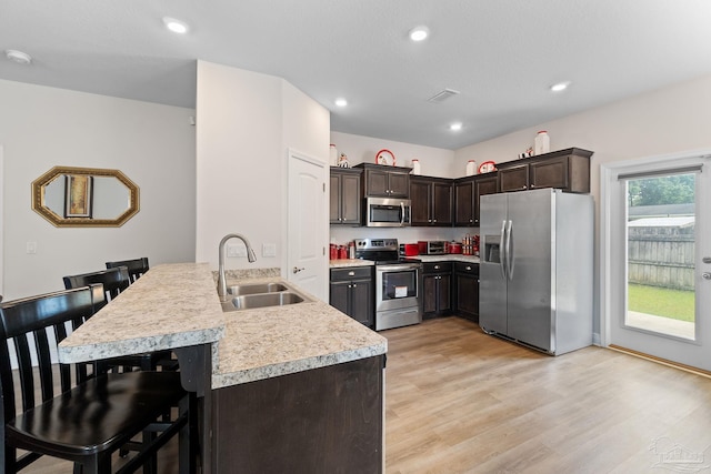 124 Polo Ter, Pensacola, FL 32534 - kitchen featuring stainless steel appliances, a sink, light countertops, dark brown cabinetry, and a kitchen bar