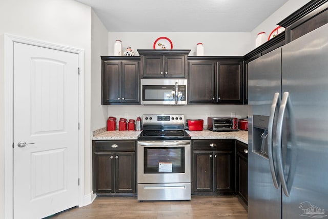 124 Polo Ter, Pensacola, FL 32534 - kitchen featuring appliances with stainless steel finishes, light wood-type flooring, and dark brown cabinets