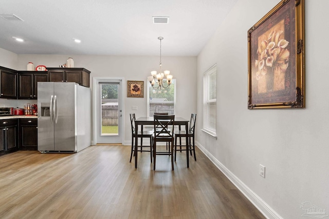 124 Polo Ter, Pensacola, FL 32534 - dining room with light wood-style floors, a chandelier, and baseboards