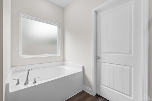 124 Polo Ter, Pensacola, FL 32534 - bathroom featuring a garden tub, wood finished floors, and baseboards