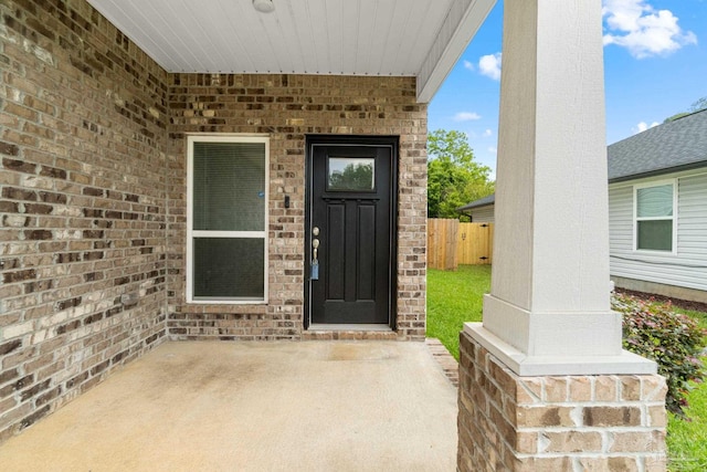 124 Polo Ter, Pensacola, FL 32534 - view of exterior entry with fence, a patio area, and brick siding
