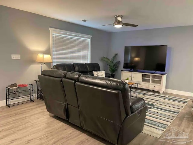 living room with light hardwood / wood-style flooring and ceiling fan