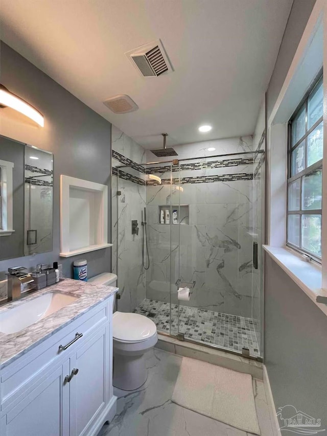 bathroom with vanity, a shower with shower door, and toilet