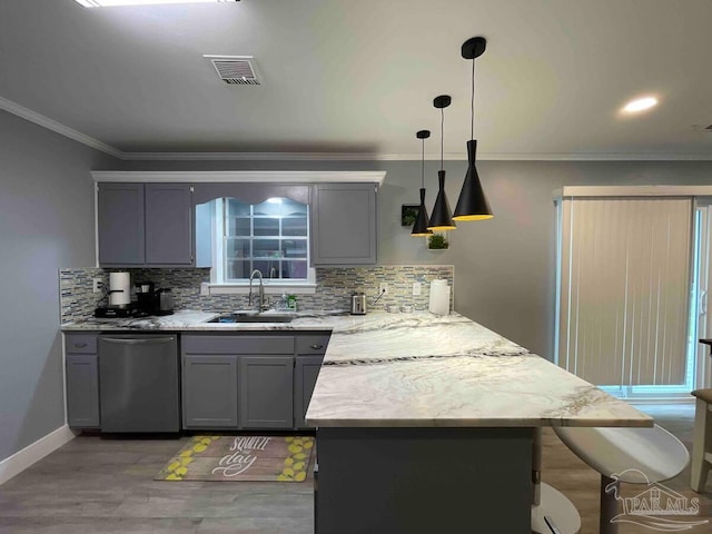 kitchen featuring dishwasher, backsplash, sink, light hardwood / wood-style flooring, and decorative light fixtures