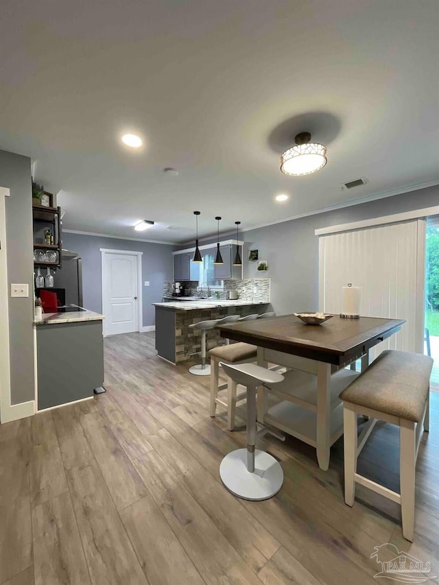 dining room featuring hardwood / wood-style floors and crown molding