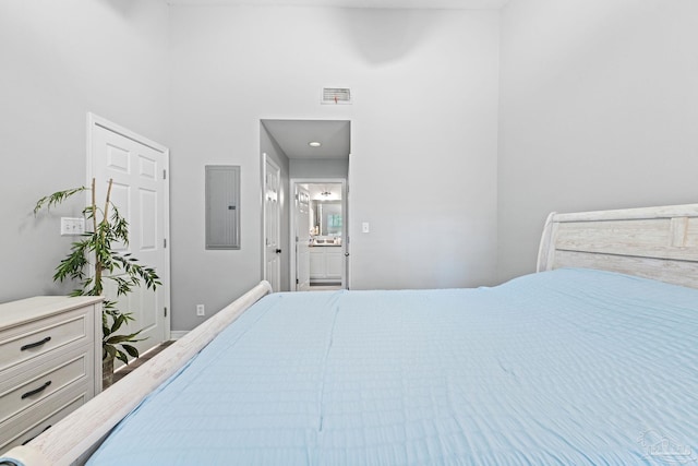 bedroom with electric panel and connected bathroom