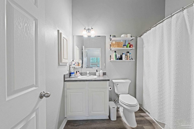 bathroom with wood finished floors, vanity, and toilet