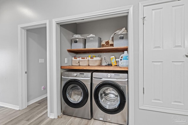 washroom featuring washing machine and dryer, light wood-style flooring, and baseboards