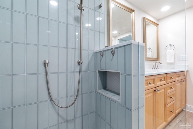 bathroom with vanity and tiled shower