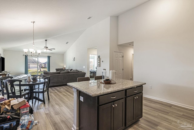 kitchen with a kitchen island, dark brown cabinetry, pendant lighting, and light hardwood / wood-style floors