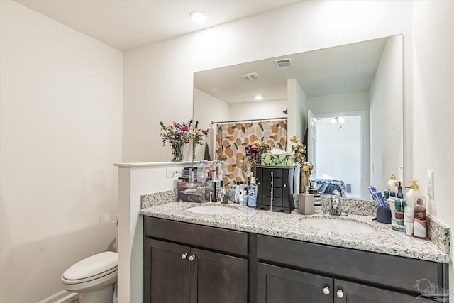 bathroom featuring vanity, toilet, and walk in shower