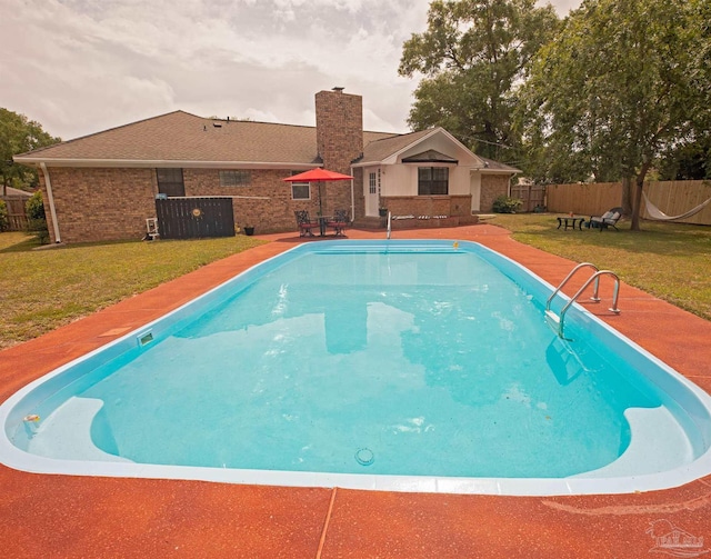 view of swimming pool with a lawn, a patio area, fence, and a fenced in pool