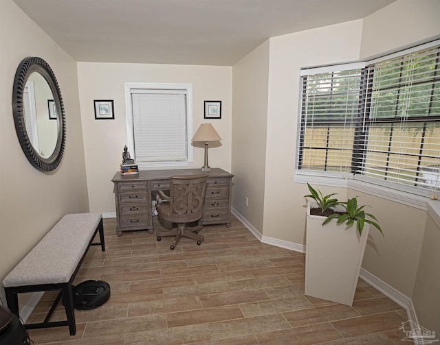 home office with baseboards and wood finished floors