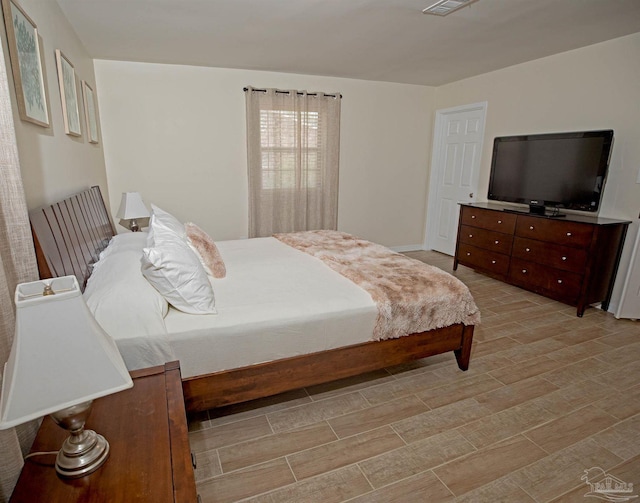 bedroom with light wood-style floors and visible vents