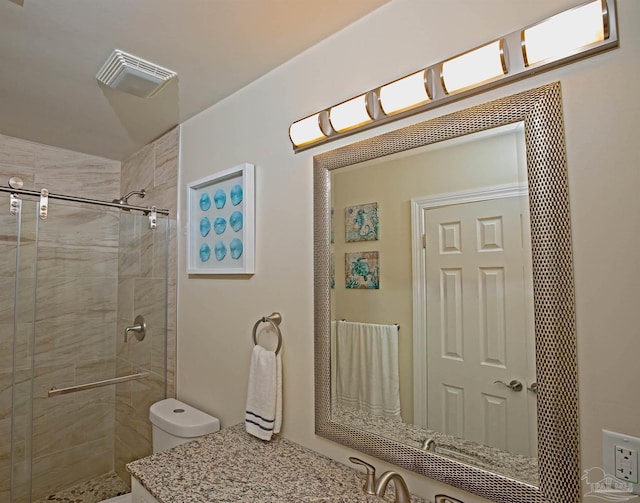 bathroom featuring vanity, a shower stall, toilet, and visible vents