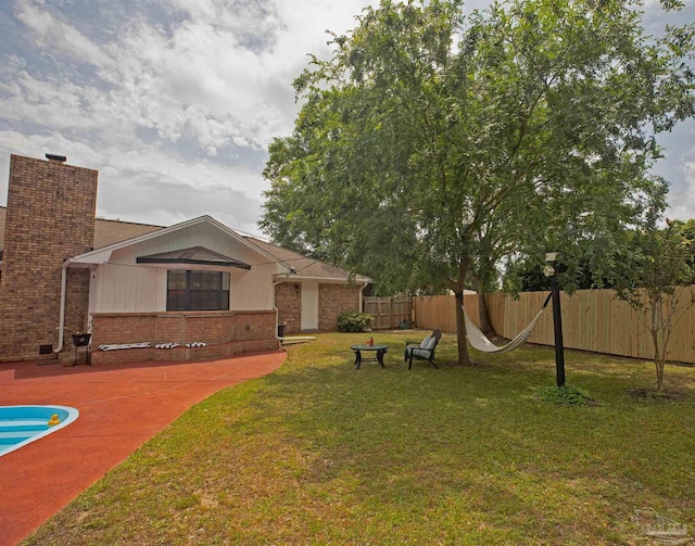 view of yard with fence and a pool