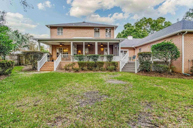 rear view of house with ceiling fan, a porch, and a yard