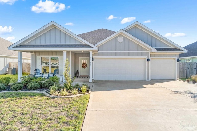 view of front of house featuring covered porch, a front lawn, and a garage