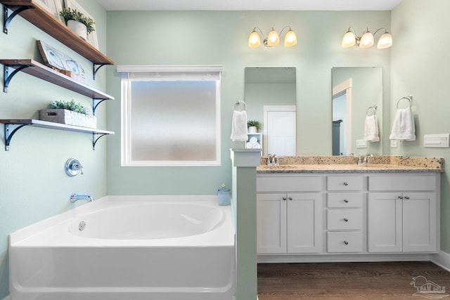 bathroom featuring vanity, a tub to relax in, and hardwood / wood-style floors