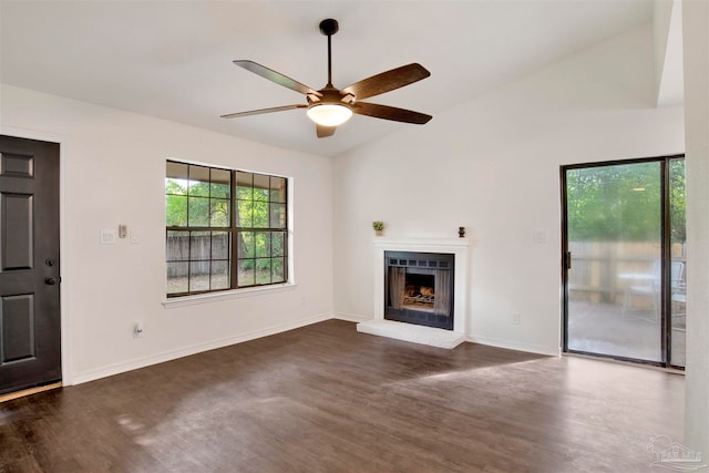 unfurnished living room featuring dark wood-type flooring, ceiling fan, vaulted ceiling, and a brick fireplace