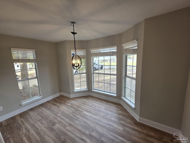 5674 Windsong Dr, Milton, FL 32570 - unfurnished dining area featuring baseboards, dark wood finished floors, and a chandelier