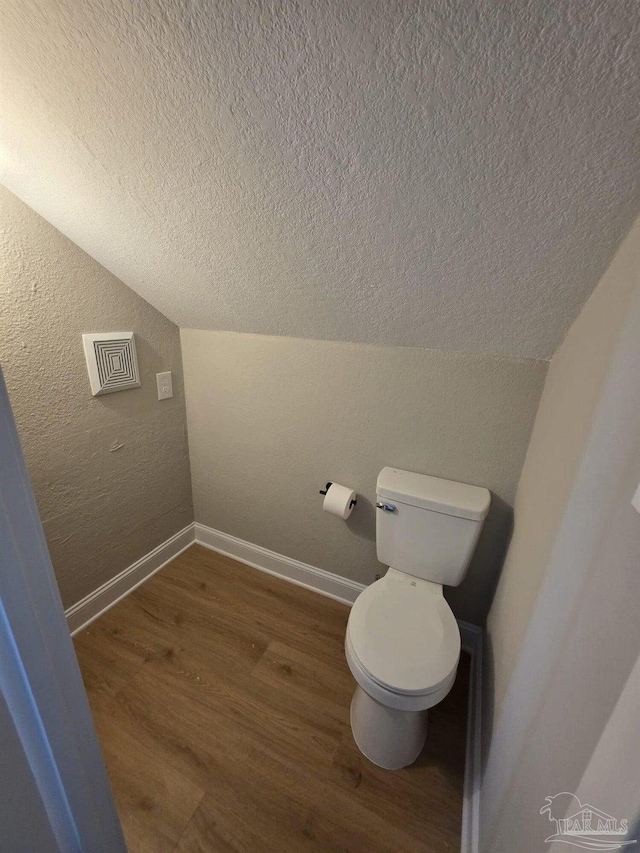 5674 Windsong Dr, Milton, FL 32570 - bathroom with a textured ceiling, wood finished floors, baseboards, vaulted ceiling, and a textured wall