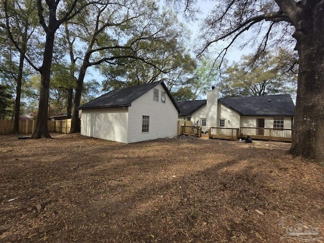 5674 Windsong Dr, Milton, FL 32570 - view of side of property featuring a wooden deck, fence, an outbuilding, and a chimney