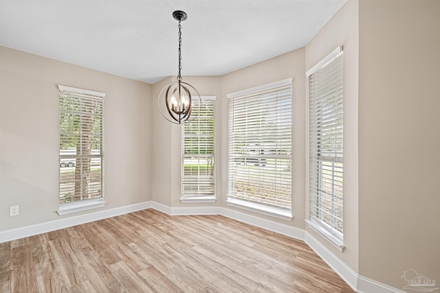 5674 Windsong Dr, Milton, FL 32570 - unfurnished dining area with light wood-type flooring, baseboards, and a chandelier