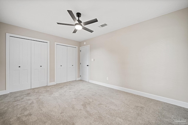 5674 Windsong Dr, Milton, FL 32570 - unfurnished bedroom with multiple closets, carpet flooring, baseboards, and a ceiling fan