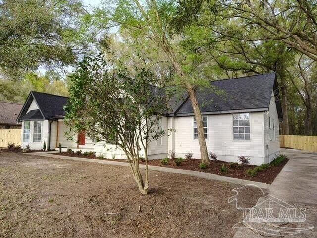 5674 Windsong Dr, Milton, FL 32570 - view of front of house featuring fence and a shingled roof