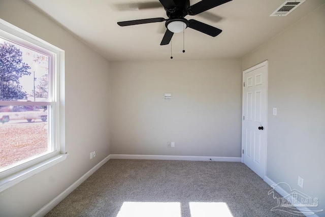 carpeted empty room featuring ceiling fan and a healthy amount of sunlight