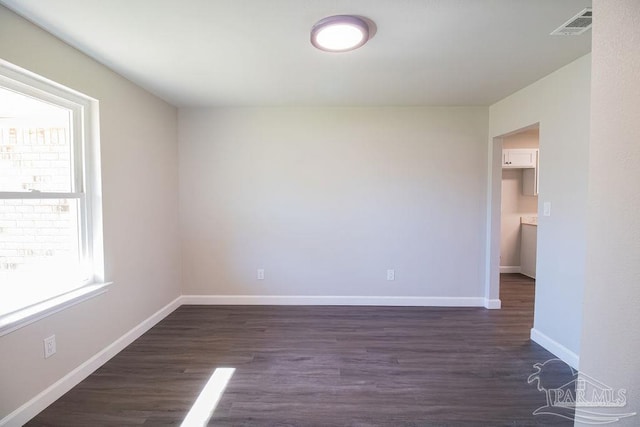 empty room with dark wood-type flooring