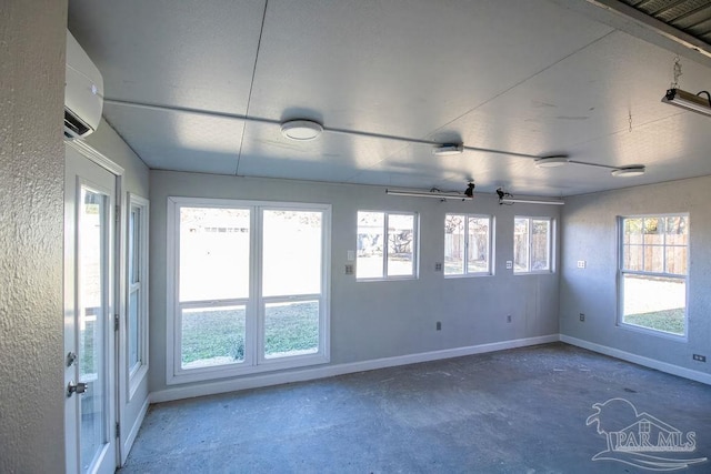 unfurnished room featuring a wall mounted air conditioner, concrete flooring, and ceiling fan