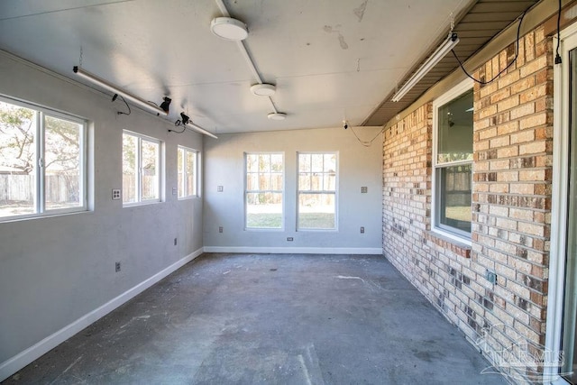 unfurnished sunroom with ceiling fan