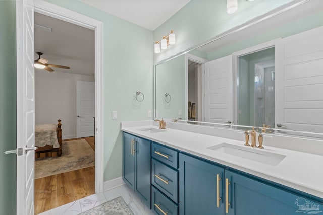 full bath featuring marble finish floor, double vanity, a sink, and a ceiling fan