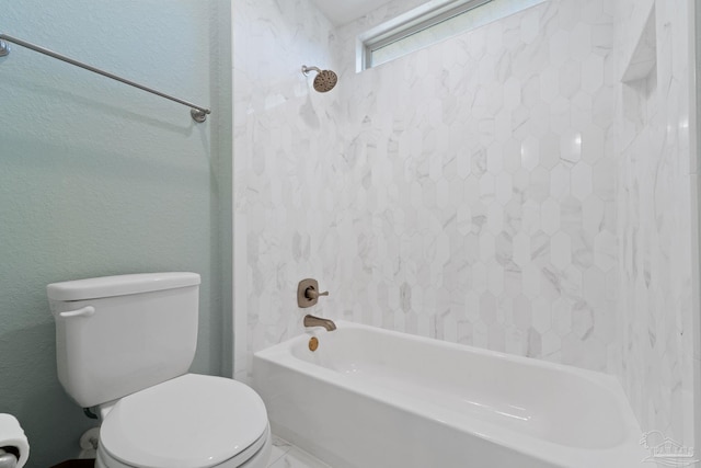 full bath with a textured wall, toilet, and shower / bathtub combination